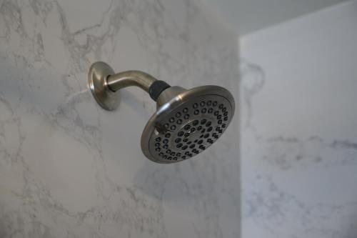 a shower with a shower head on a wall at Shell Beach Inn in Pismo Beach