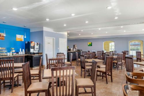 a restaurant with tables and chairs and a bar at Quality Inn & Suites at The Outlets Mercedes-Weslaco in Mercedes