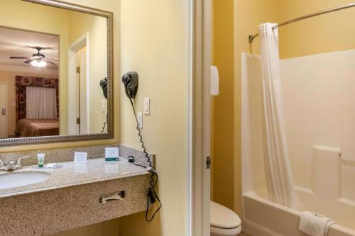 a bathroom with a sink and a shower and a mirror at Quality Inn & Suites at The Outlets Mercedes-Weslaco in Mercedes