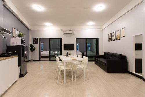 a kitchen and a living room with a table and chairs at U2 Large 2 Bedrooms 100m to BTS station in Bangkok