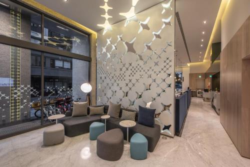 a lobby with a couch and tables in a building at Ramble Hotel in Taichung