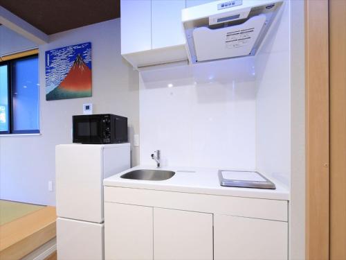 uma cozinha com um lavatório e um frigorífico em COTO Tokyo Asakusa 5 em Tóquio