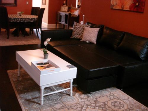 a living room with a black couch and a table at House in Soulard with Parking in Maryland Heights