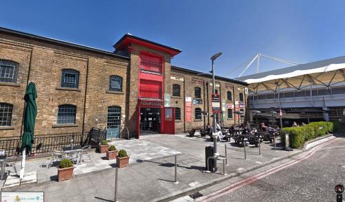 a group of buildings with tables and chairs in a courtyard at SNG Apartments Excel in London