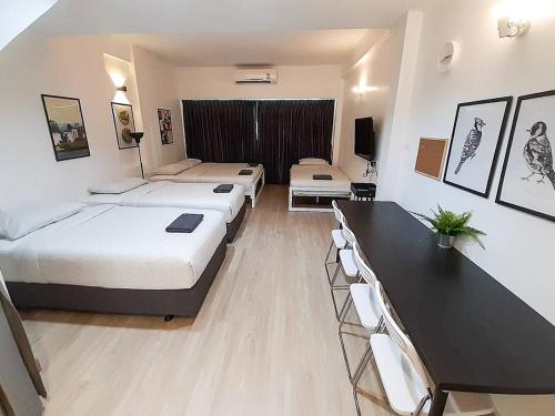 a room with three beds and a table and chairs at B3 Cosy Studio /5 guests/ Near MRT/full kitchen in Bangkok