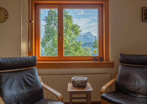 a room with a window and two chairs and a table at Alpeambient house Dovje in Mojstrana