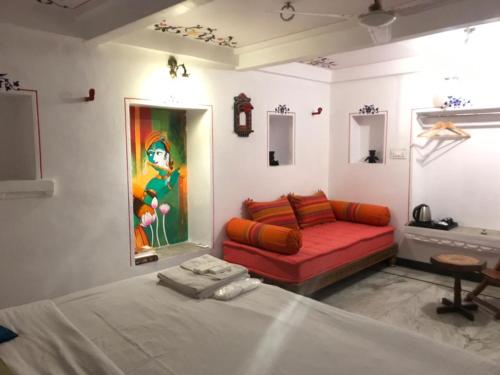 a room with a bed and a couch in it at Hari Niwas Guest House in Udaipur