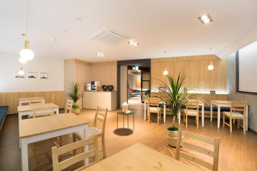 a restaurant with wooden tables and chairs and a dining room at Brown Dot Hotel Jinju in Jinju