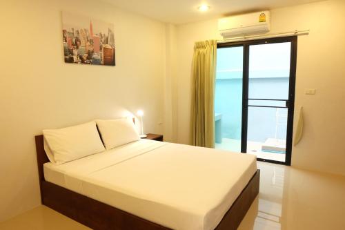 a bedroom with a bed and a large window at 3B Apartment-SHA Extra Plus in Kamala Beach