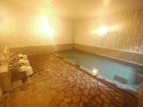 a bathroom with a large pool of water in a tub at Hotel Route-Inn Kani in Kani