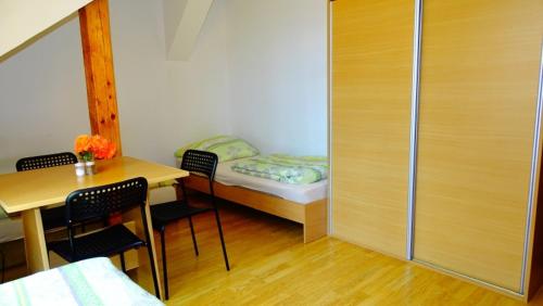 a small room with a bed and a table and chairs at Noclegi "Marek i Karolina" in Cieszyn