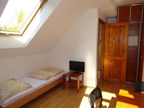 a bedroom with a bed and a tv and a window at Noclegi "Marek i Karolina" in Cieszyn