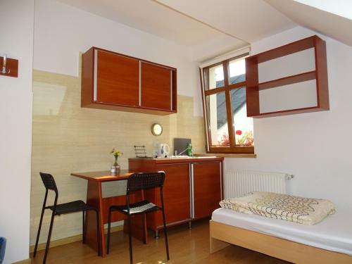 a room with a desk and a bed and a table at Noclegi "Marek i Karolina" in Cieszyn