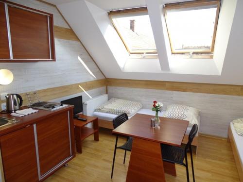 a small room with a table and a kitchen with a couch at Noclegi "Marek i Karolina" in Cieszyn