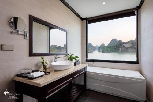 a bathroom with a sink and a tub and a window at Mon Chéri Cruises in Ha Long