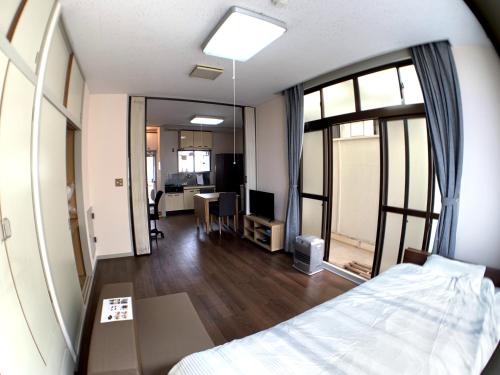 ein Schlafzimmer mit einem Bett und ein Zimmer mit einem Schreibtisch in der Unterkunft Big Stone Tsukuda 41平米 2F in Aomori