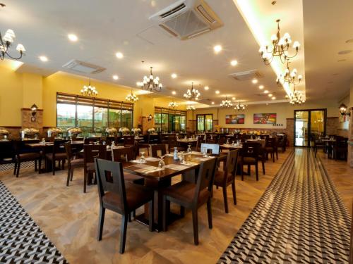 a dining room with tables and chairs and chandeliers at Sunlight Hotel Coron in Coron