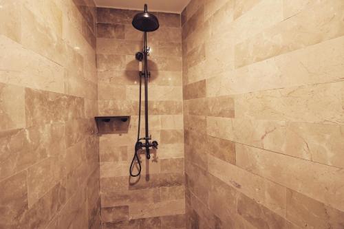 a shower in a bathroom with a stone wall at The Twelve Manor•Terraces Lodge in Yuanyang