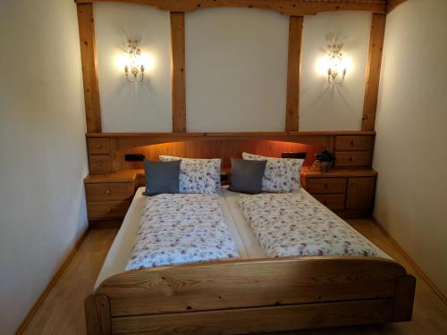 a bedroom with a large wooden bed with two pillows at Landhaus Mayer in Alpbach