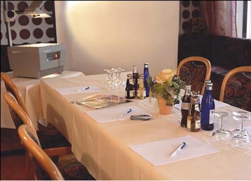 a table with bottles of wine and flowers on it at WeinBergHotel Nalbach in Reil