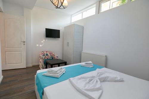a bedroom with a bed with two towels on it at Stanford Aparthotel in Bucharest
