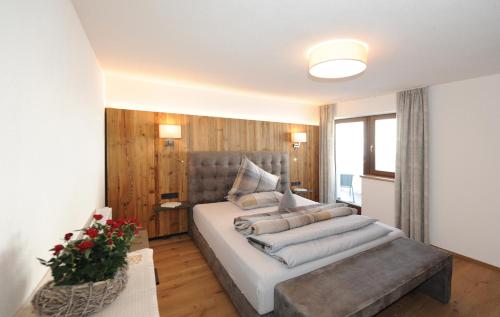 a bedroom with a large bed with a gray headboard at Ferienwohnungen Familie Niedermoser Stefan in Sankt Jakob in Haus