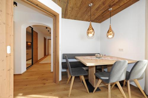 a dining room with a wooden table and chairs at Ferienwohnungen Familie Niedermoser Stefan in Sankt Jakob in Haus