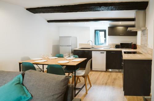 une cuisine et une salle à manger avec une table et des chaises dans l'établissement T3 duplex design hypercentre Cathédrale Narbonne, à Narbonne