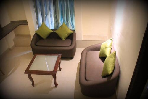 a living room with a couch and a coffee table at Magnus Calypso Suites Viman Nagar in Pune