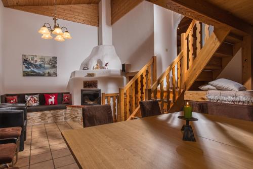 a dining room with a wooden table and a staircase at Ferienhaus "Kaprun" in Kaprun