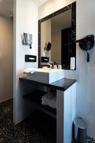 a bathroom with a sink and a mirror at Best Western Central Hotel in Tours