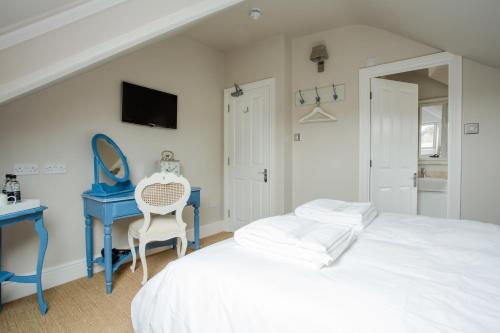 a bedroom with a white bed and a blue desk at Grays Boutique B&B in Bath