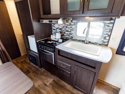 a small kitchen with a sink and a stove at Beach Resort Hotel Kalakaua in Onna