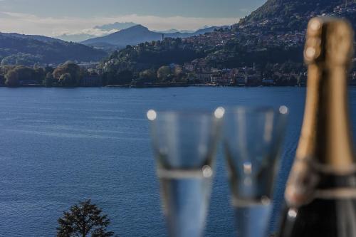 a pair of wine glasses with a view of a lake at Locanda Bella Fra in Blevio