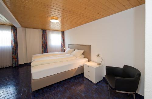 a bedroom with a bed and a desk and a chair at Landgasthof Werdenberg in Werdenberg