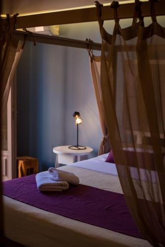 a bedroom with a bed with a canopy and a table at Elia Potie in Chania Town