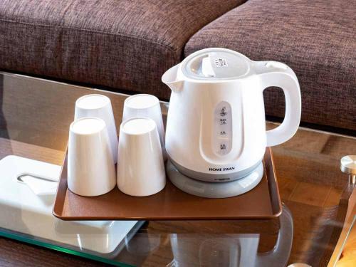 a white appliance on a glass table next to a couch at Beach Resort Hotel Kalakaua in Onna