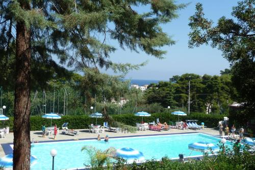 una piscina con sedie e ombrelloni di Happy Camp mobile homes in Camping Villaggio Internazionale a San Menaio