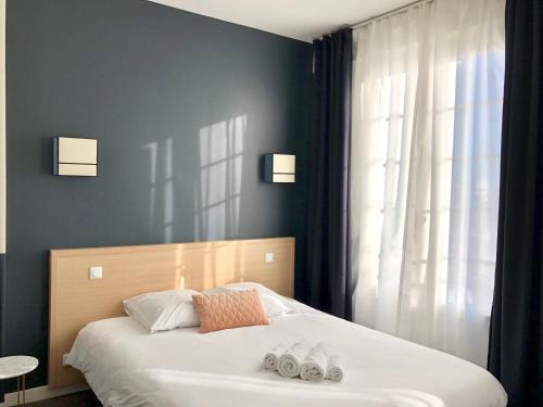 a bedroom with a bed with two shoes on it at Hotel Saint Louis in Brest
