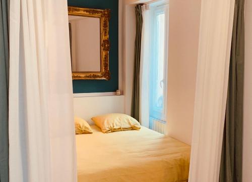 una camera da letto con un letto con specchio e una finestra di Studio Olive a La Ciotat