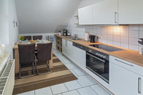 a kitchen with white appliances and a counter top at Nordsee-Nest in Ostochtersum