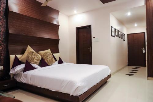 a bedroom with a large bed with a wooden headboard at Vijan Palace in Jabalpur