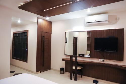 a bathroom with a large mirror and a television at Vijan Palace in Jabalpur