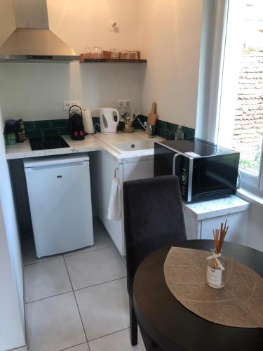 a small kitchen with a table and a microwave at Appart-Hôtel Résidence de Garonne in Tonneins