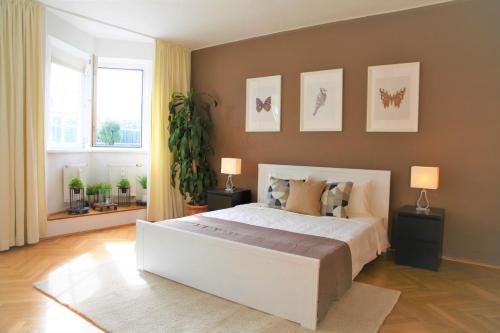 um quarto com uma grande cama branca e 2 candeeiros em Modern apt in the most famous city postcard em Innsbruck