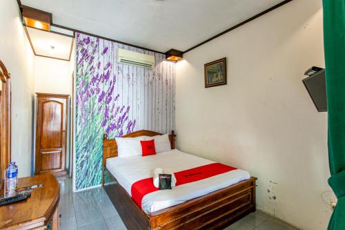 a small bedroom with a bed and a desk at RedDoorz Plus near Taman Sari 2 in Yogyakarta