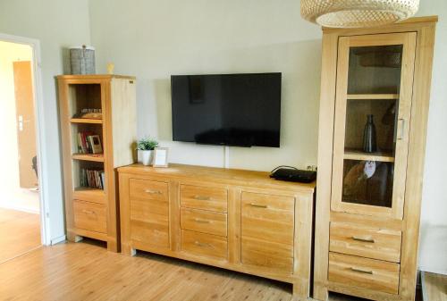 ein Entertainment-Center mit einem Flachbild-TV an der Wand in der Unterkunft Apartment Anna in Chemnitz