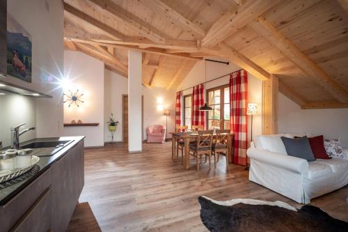 a kitchen and living room with a white couch and a table at Beim Neuner - Zeit zu zweit in Oberaudorf