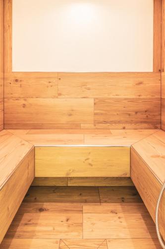 an empty sauna with wooden floors and a window at Hotel Erna in Colle Isarco