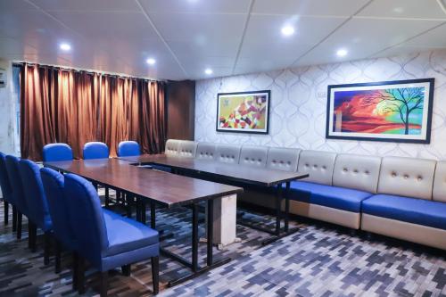 a conference room with a table and blue chairs at Vijan Palace in Jabalpur